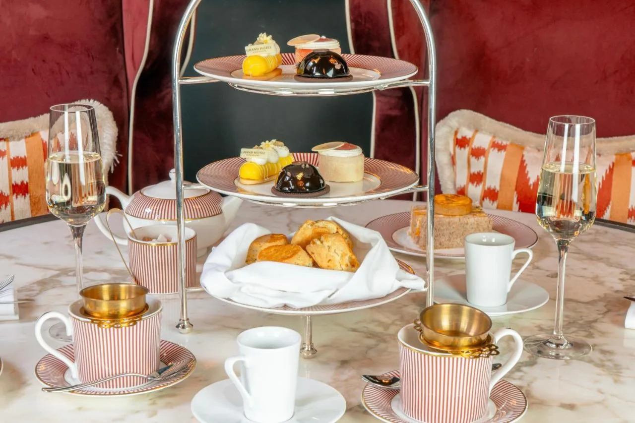 a table with plates of pastries and cups and glasses at The Grand Hotel Birmingham in Birmingham
